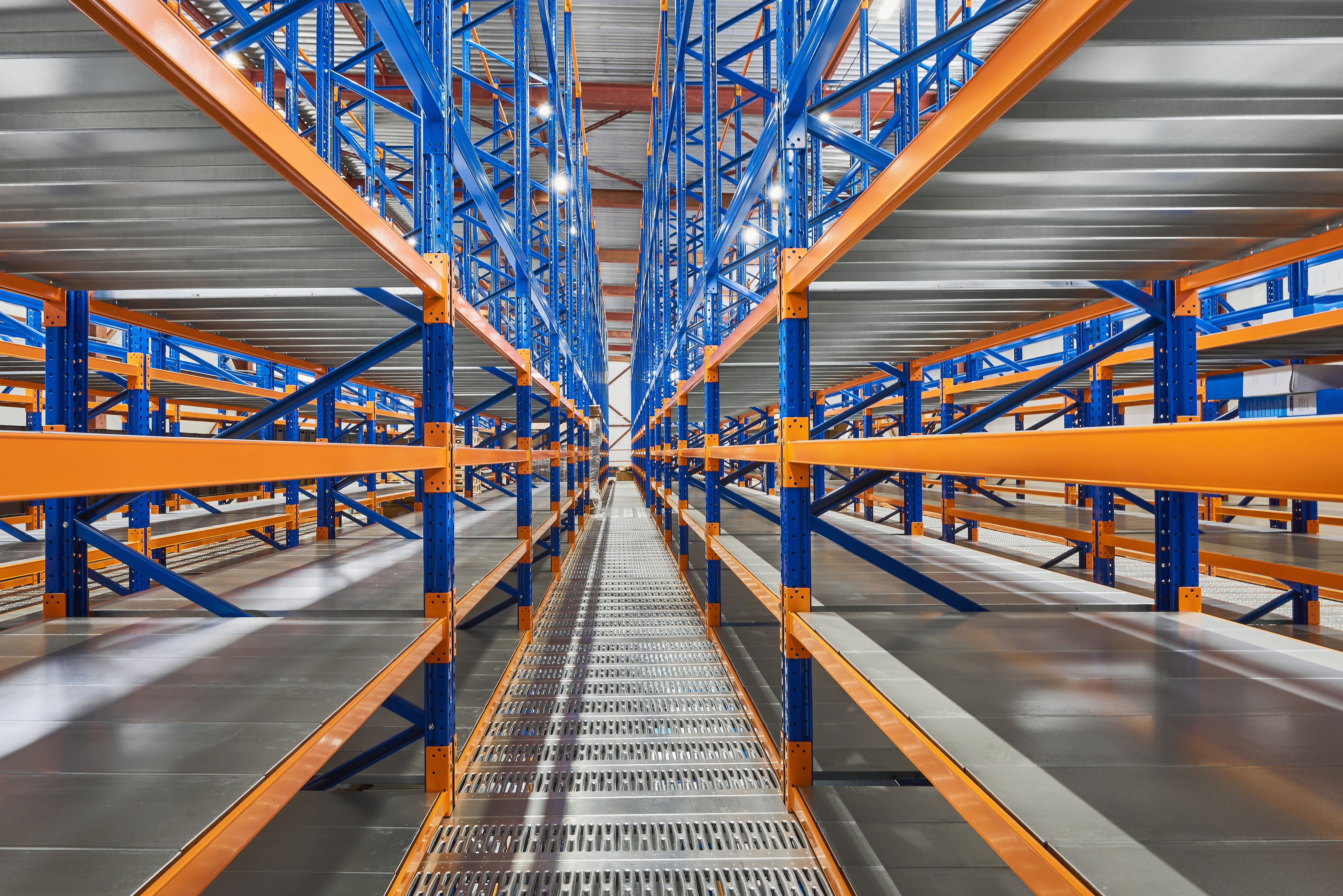 Empty shelves in new distribution warehouse. Metal equipment for storage, racks blue orange, pallet racking system